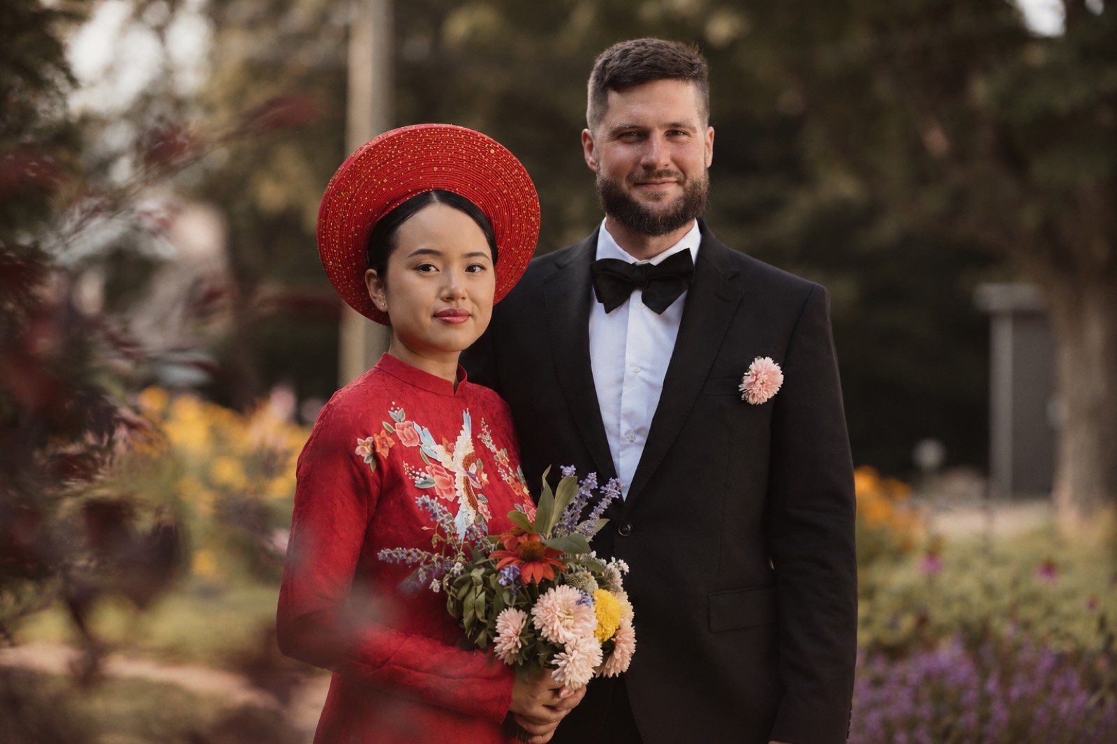 Thu and Simon in the garden at their barn wedding in Rougemont, Quebec