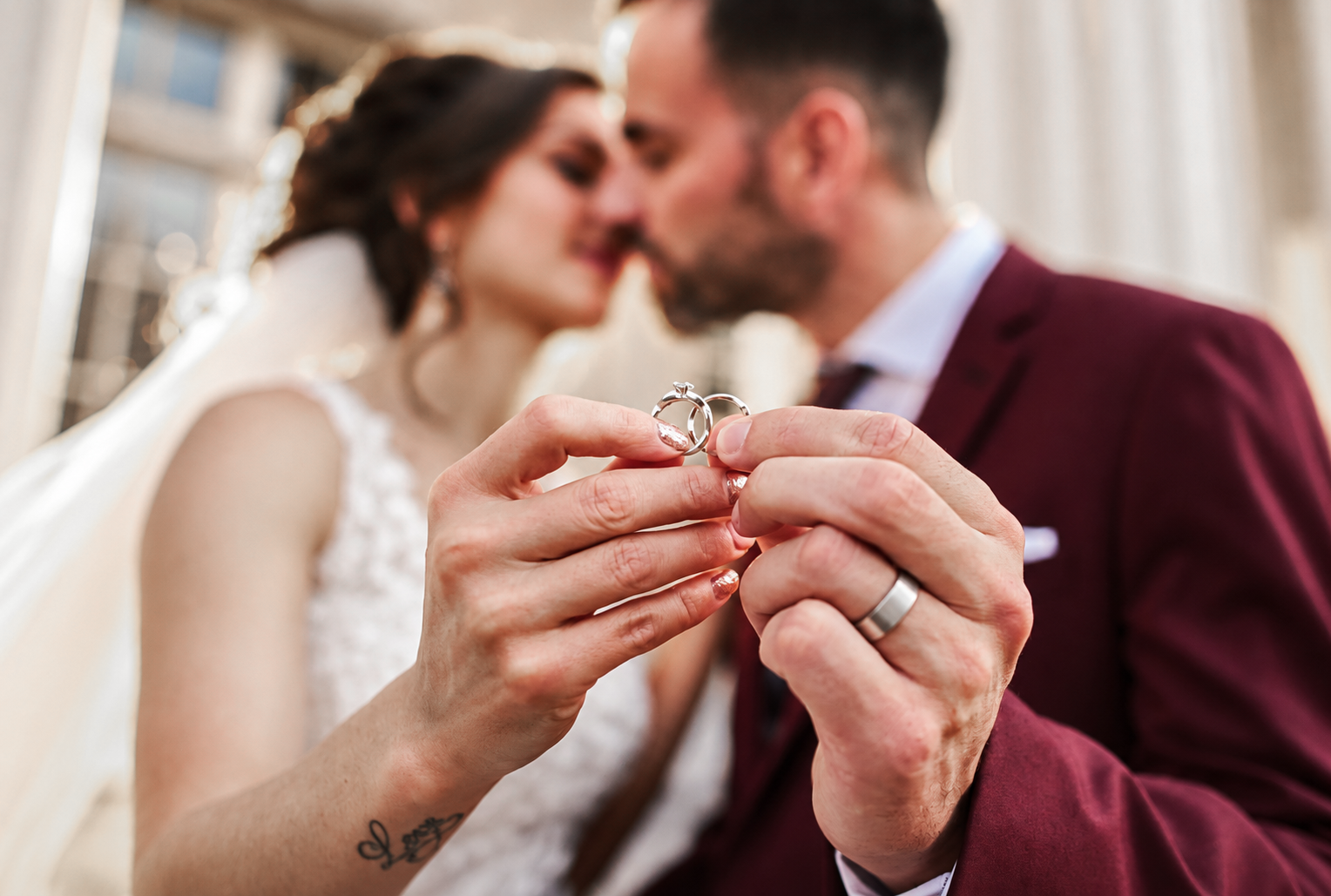 Kristine and Kenneth holding their wedding rings